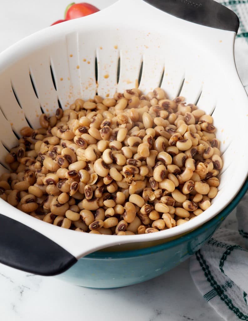 Draining the black eyed peas.