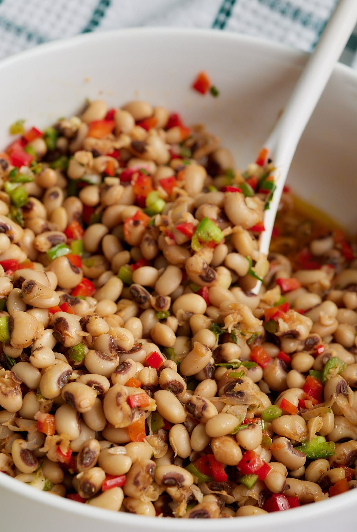 A spoon mixing together the black eyed pea salad.