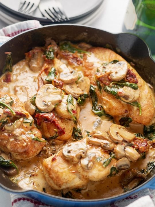 Cooked chicken and sauce in a skillet.