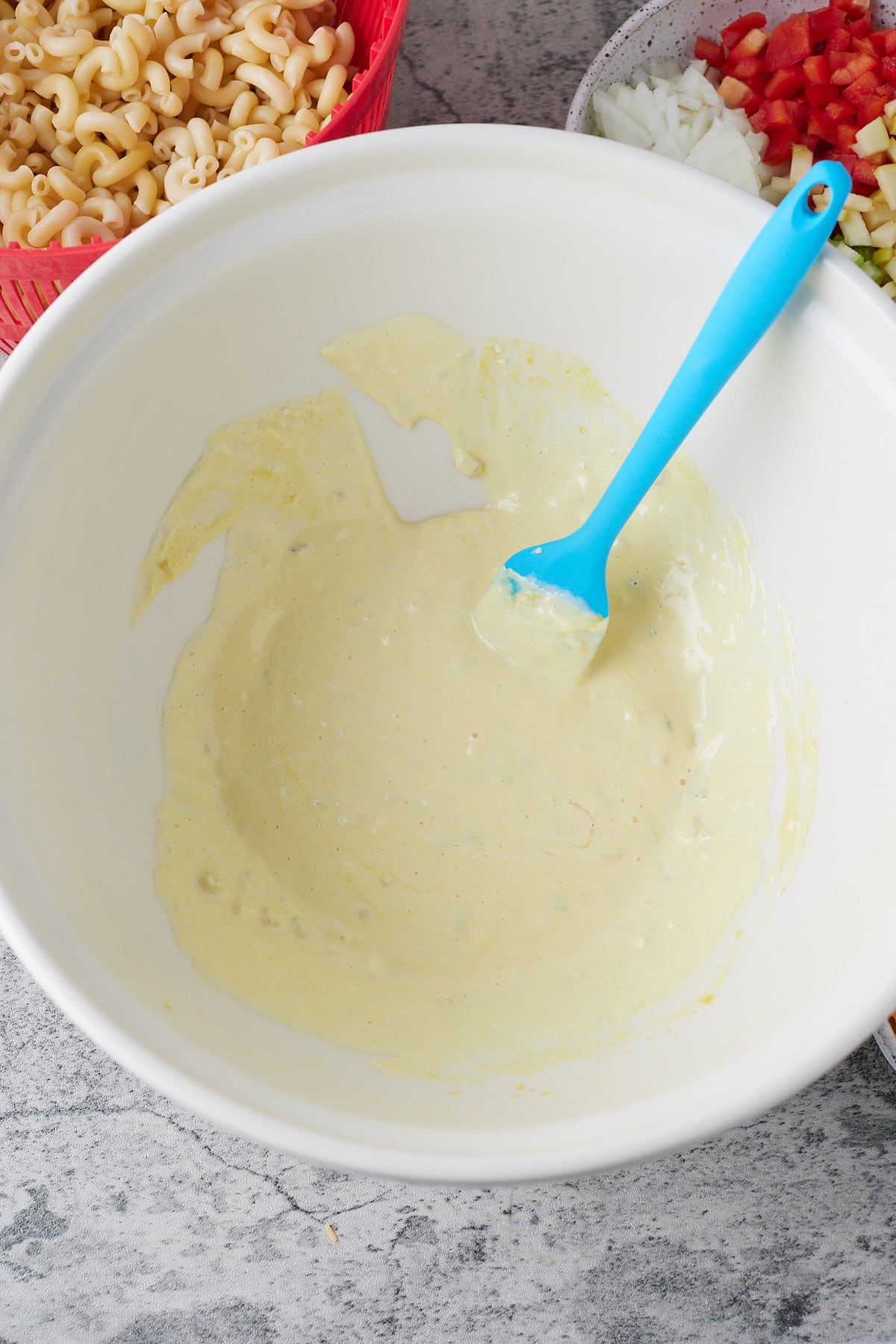 Stirring the salad dressing together in a bowl.