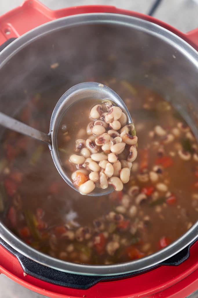 blackeye peas on spoon over pressure cooker
