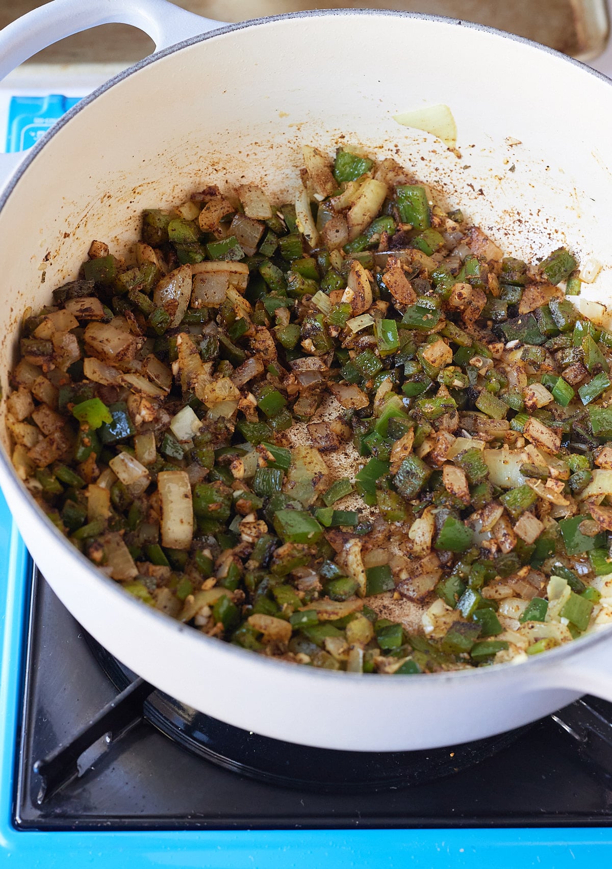 satueéd peppers and onions inside of large pot