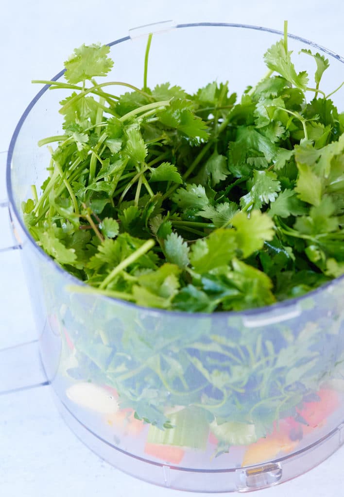 ingredients for green seasoning in a food processor