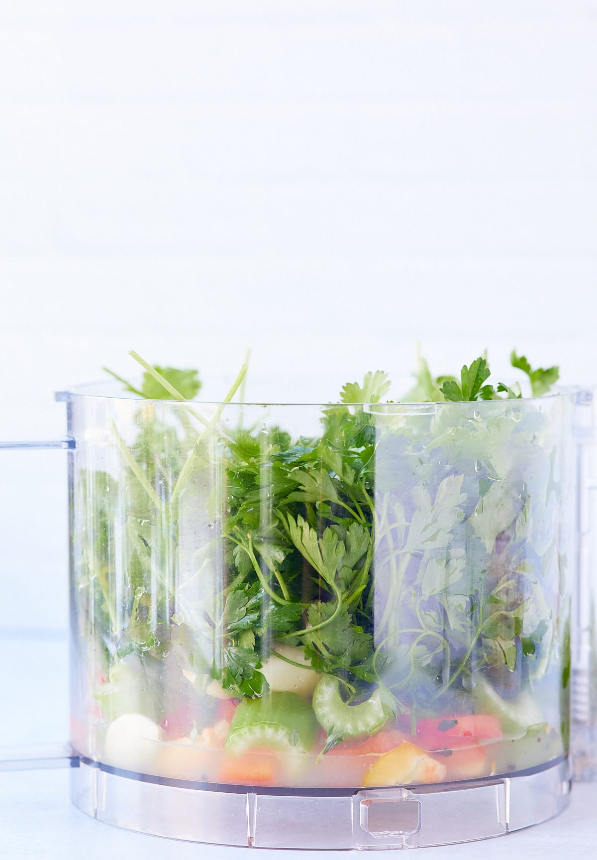 green seasoning ingredients in a food processor