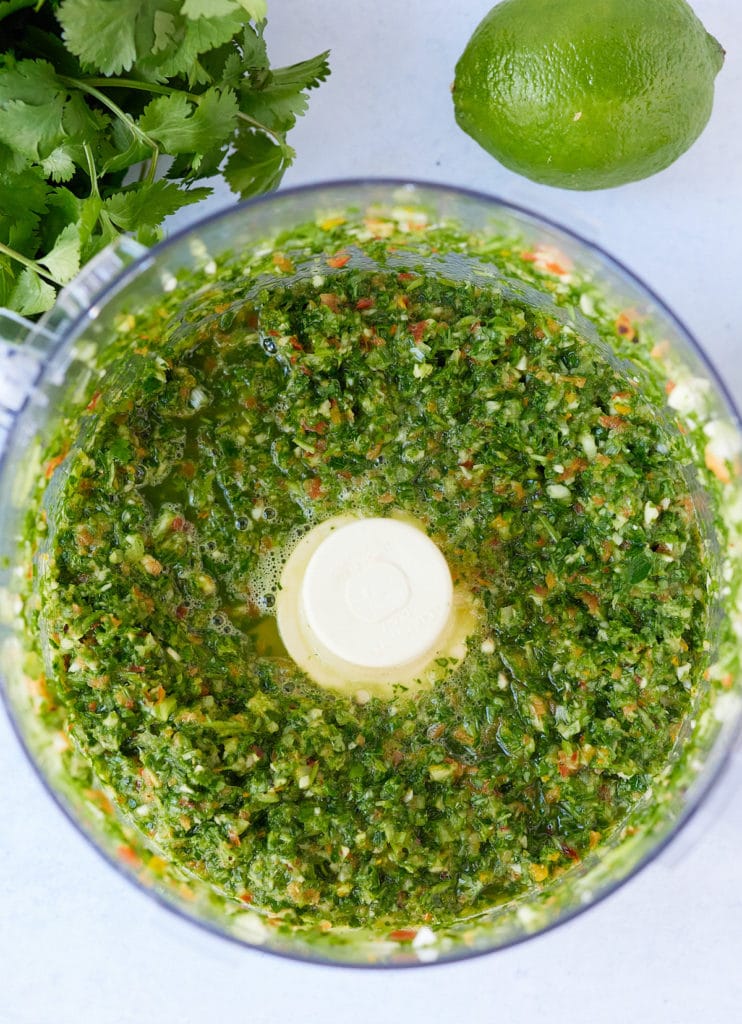 overhead photo of green seasoning in food processor