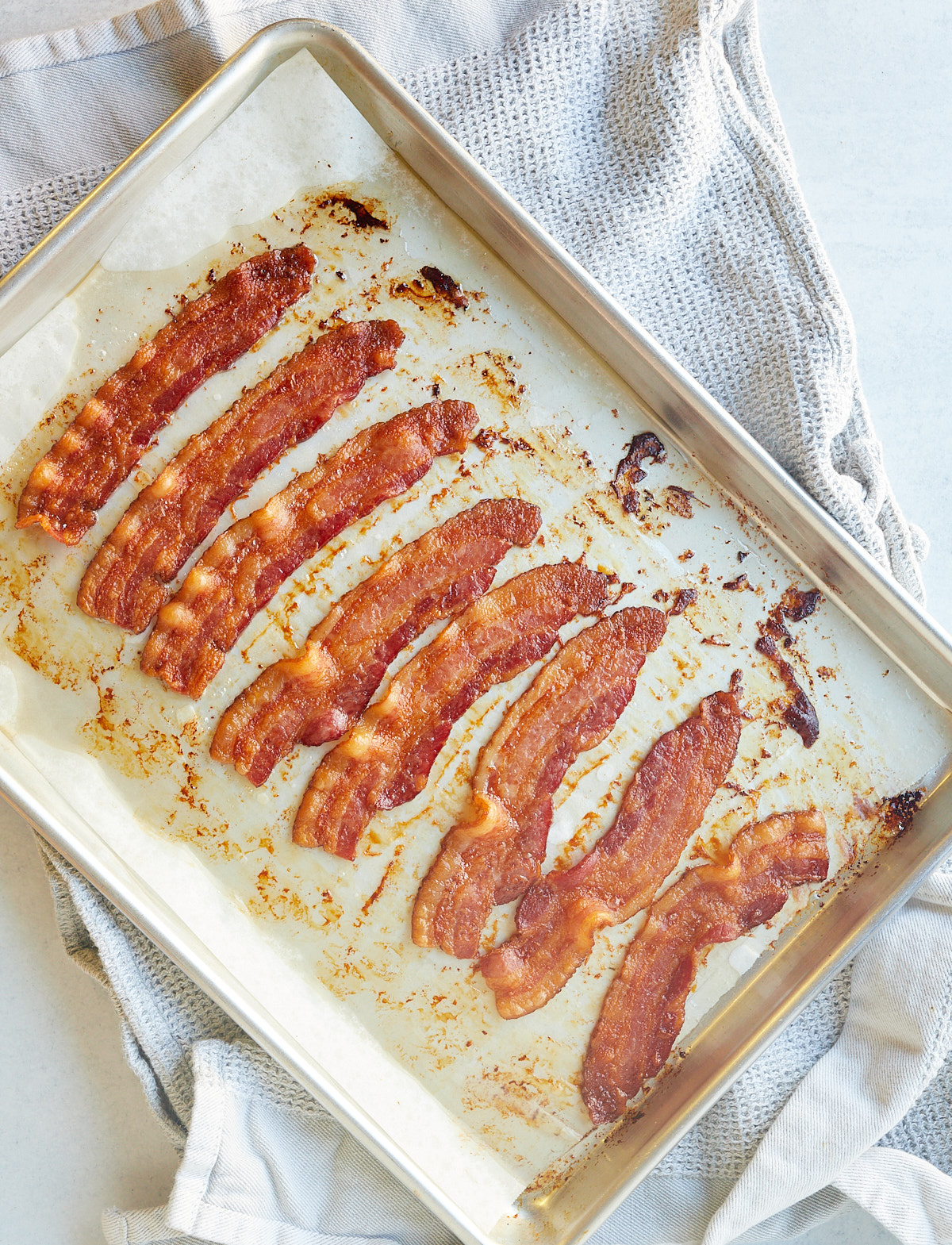 Strips of oven baked crispy bacon on a baking sheet.