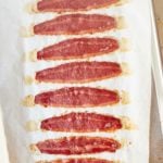 Eight strips of oven baked turkey bacon on a baking sheet.