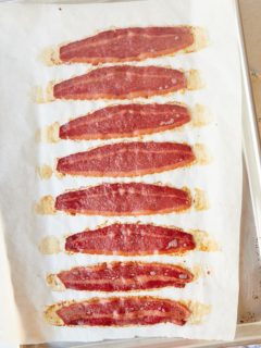 Eight strips of oven baked turkey bacon on a baking sheet.
