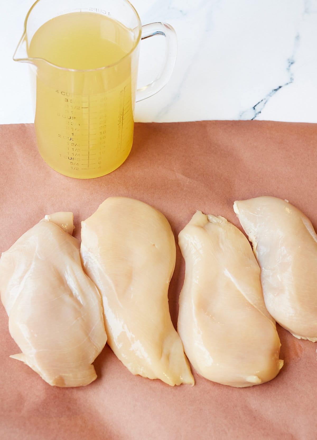 chicken broth and raw chicken breast before cooking