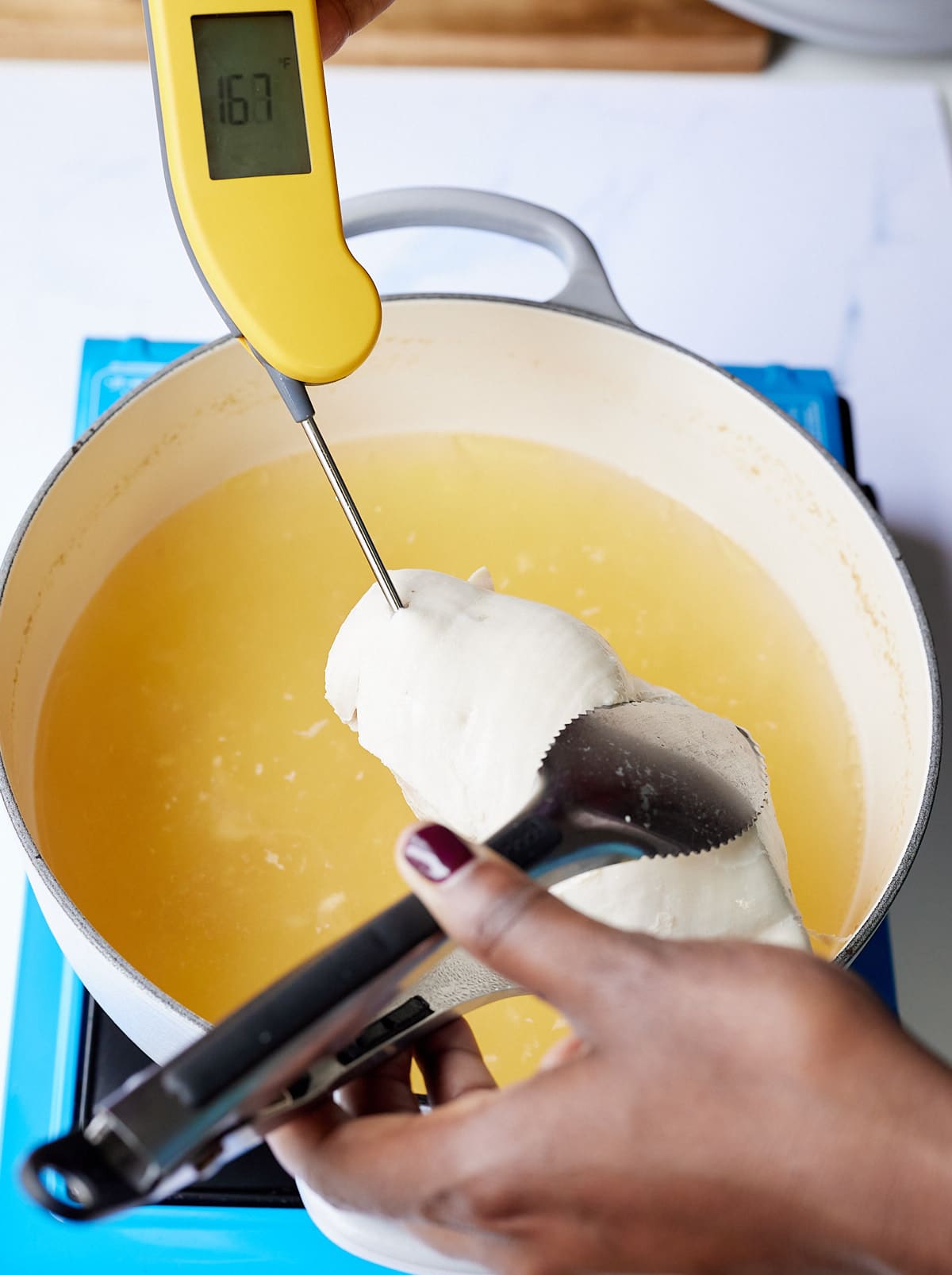 temperature checking chicken breast with yellow thermometer