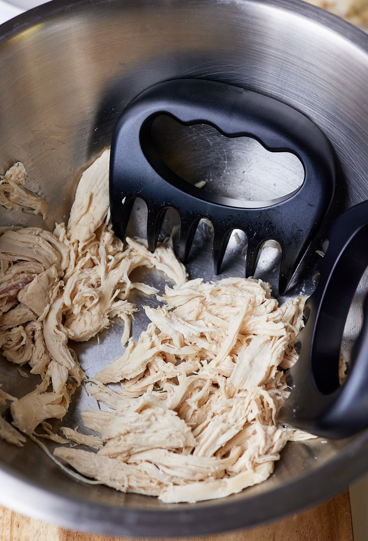 shredded chicken breast in bowl with shredding claws