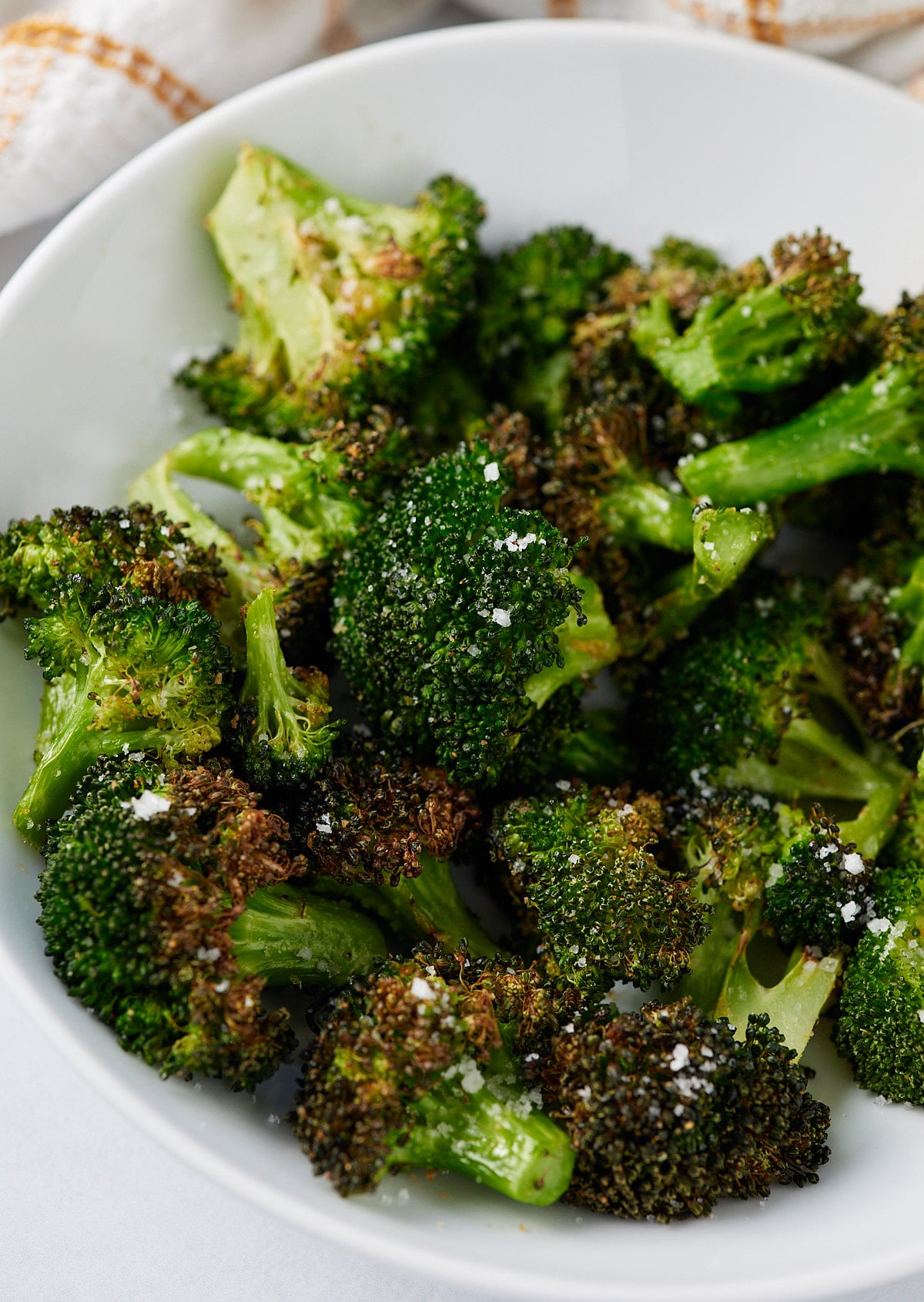 Air fryer broccoli served in a white bowl.