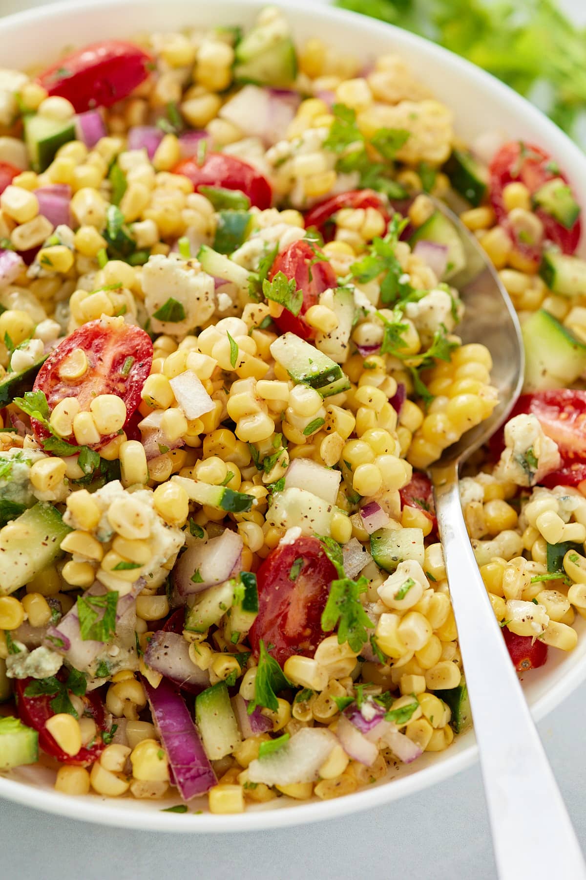 Close up of a spoon in the fresh corn salad.