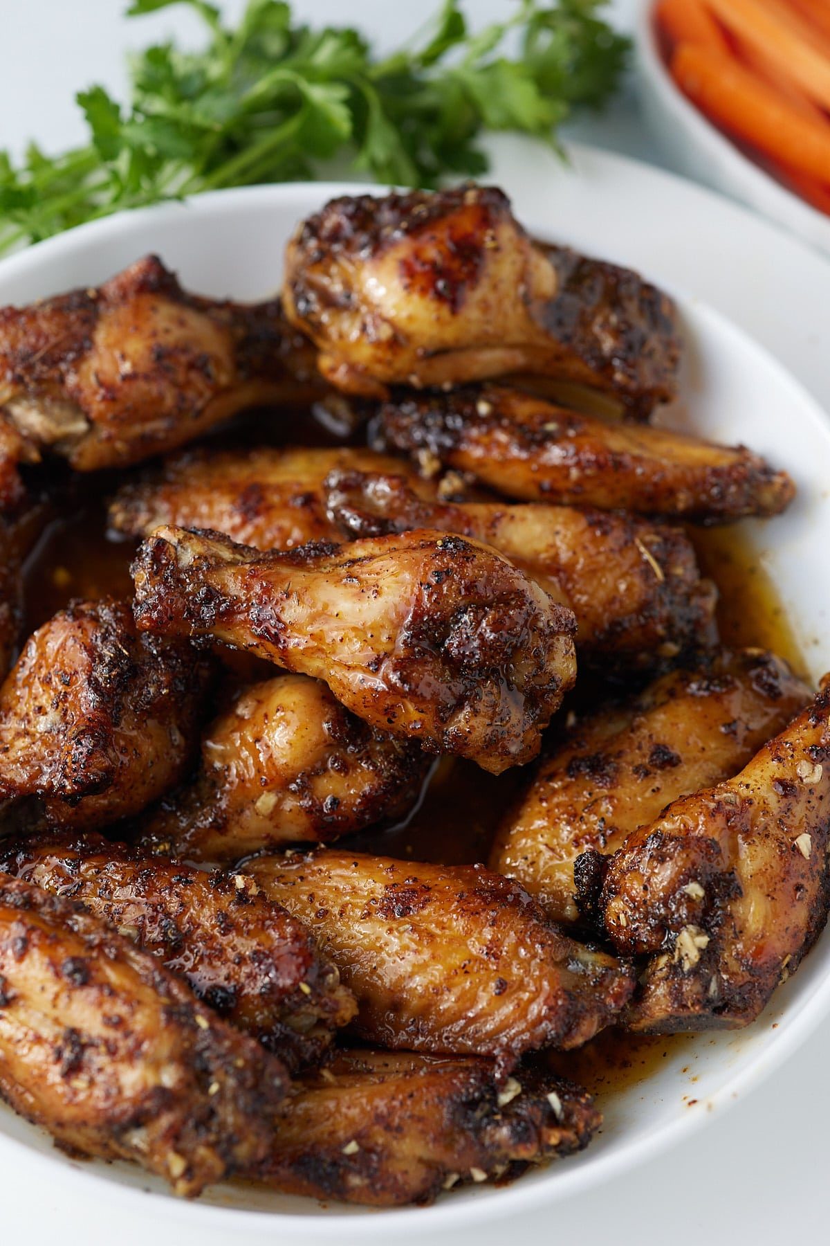 Honey garlic chicken wings served on a white plate.