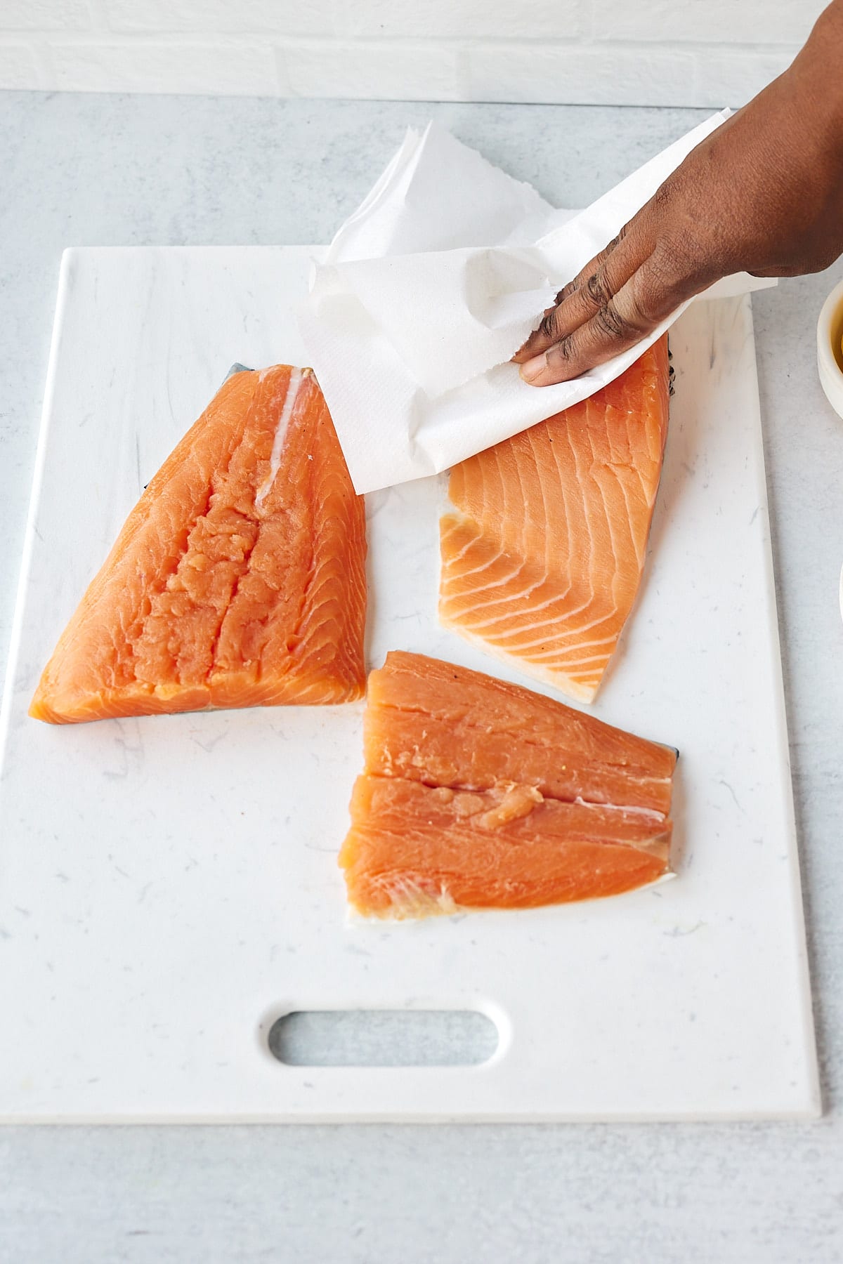 Patting salmon fillets dry.