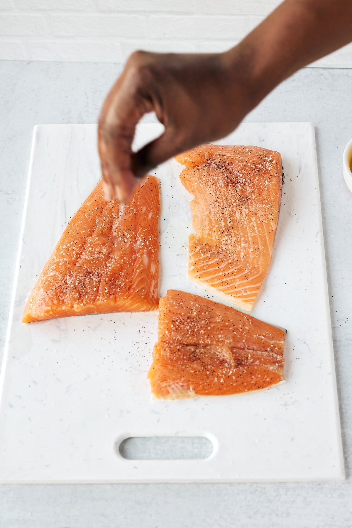 Seasoning salmon fillets.