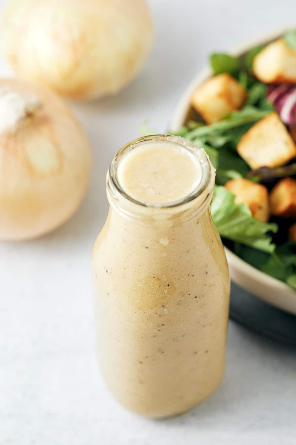 Overhead shot of a bottle of onion salad dressing.