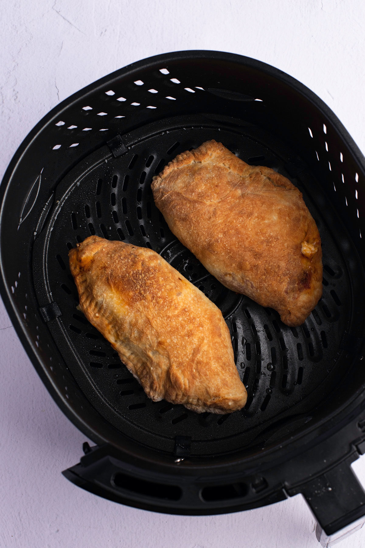 finished air fryer calzones in air fryer basket