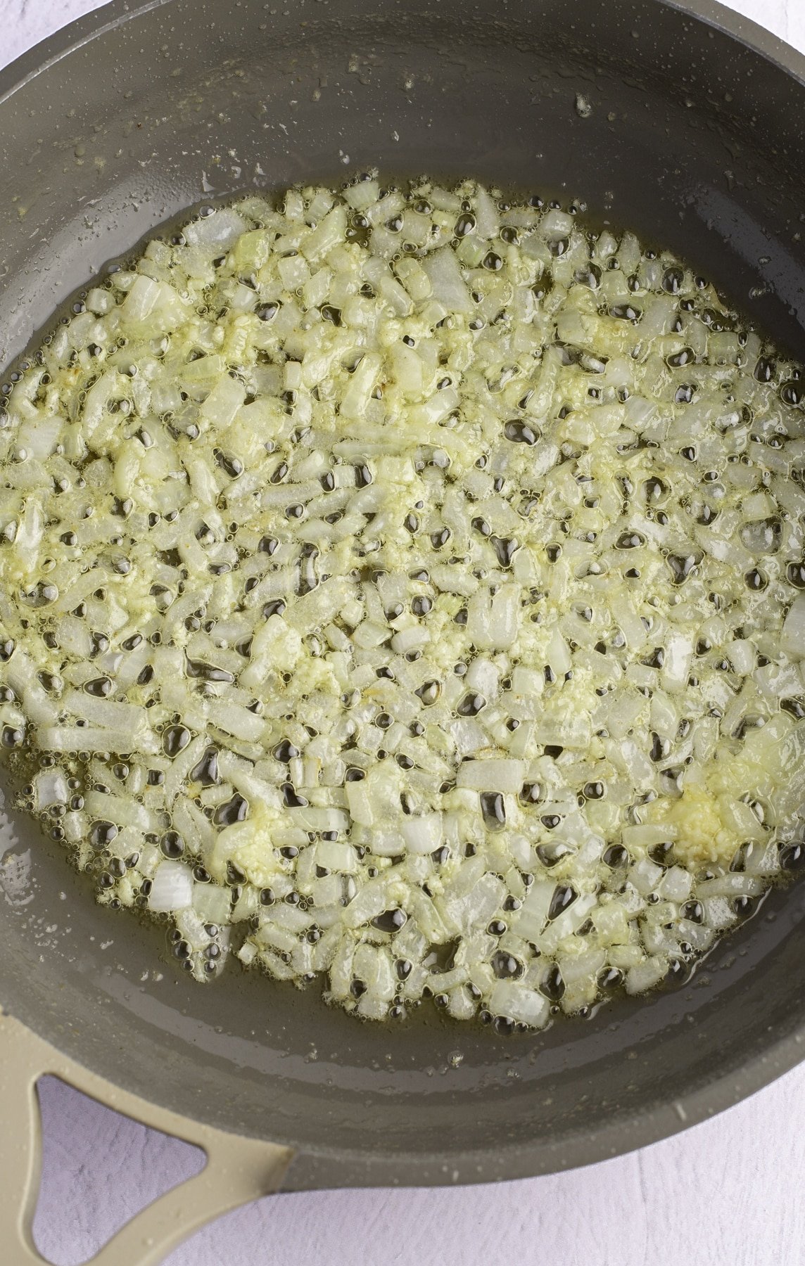 Onion and garlic cooking in a skillet.