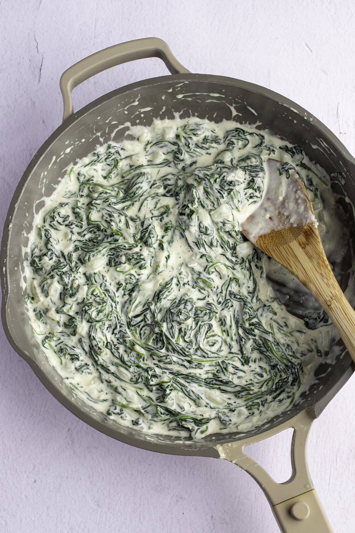 Stirring the spinach and parmesan into the cream.