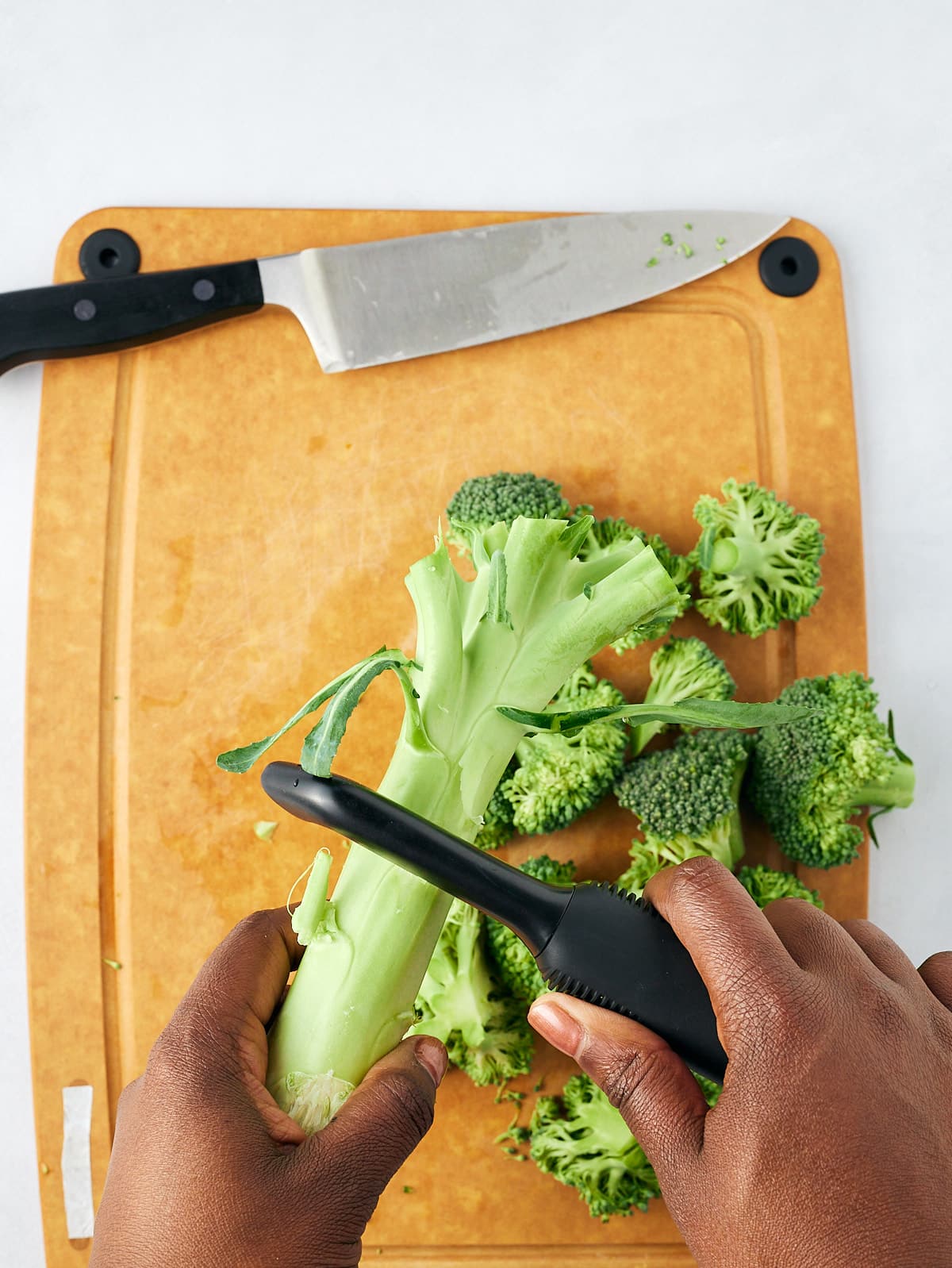 vegetable peeler peeling the broccoli stem