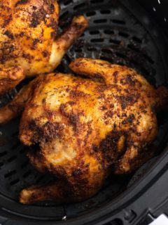 A cooked cornish hen in the air fryer basket.