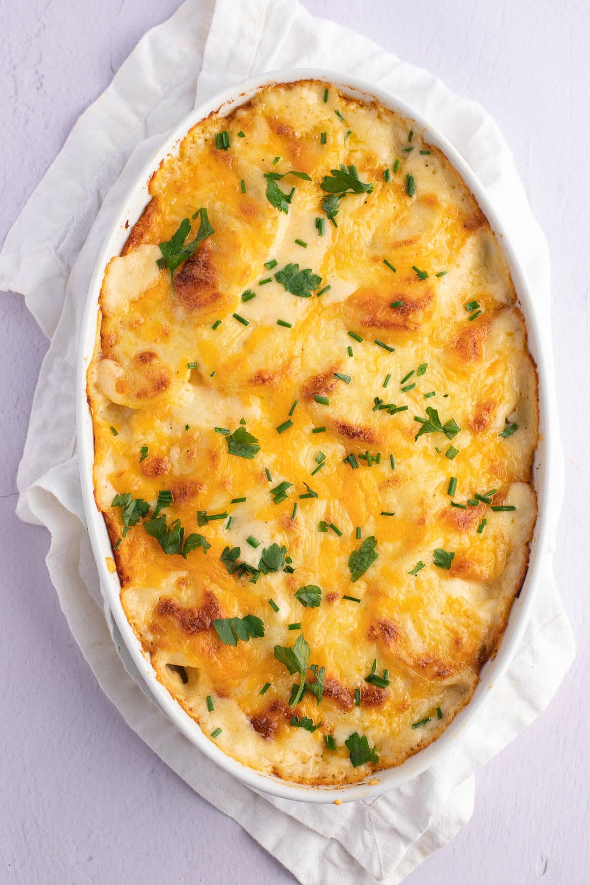 Baked scalloped potatoes in a white dish.