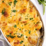 Overhead shot of scalloped potatoes in a white baking dish.