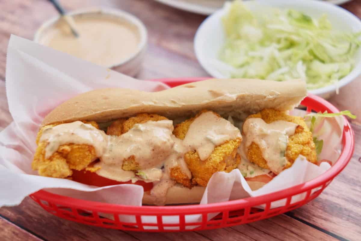 A shrimp po'boy sandwich served in a red basket.