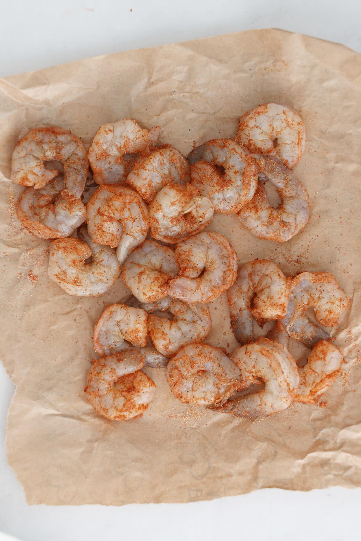 Seasoned shrimp on a piece of parchment.