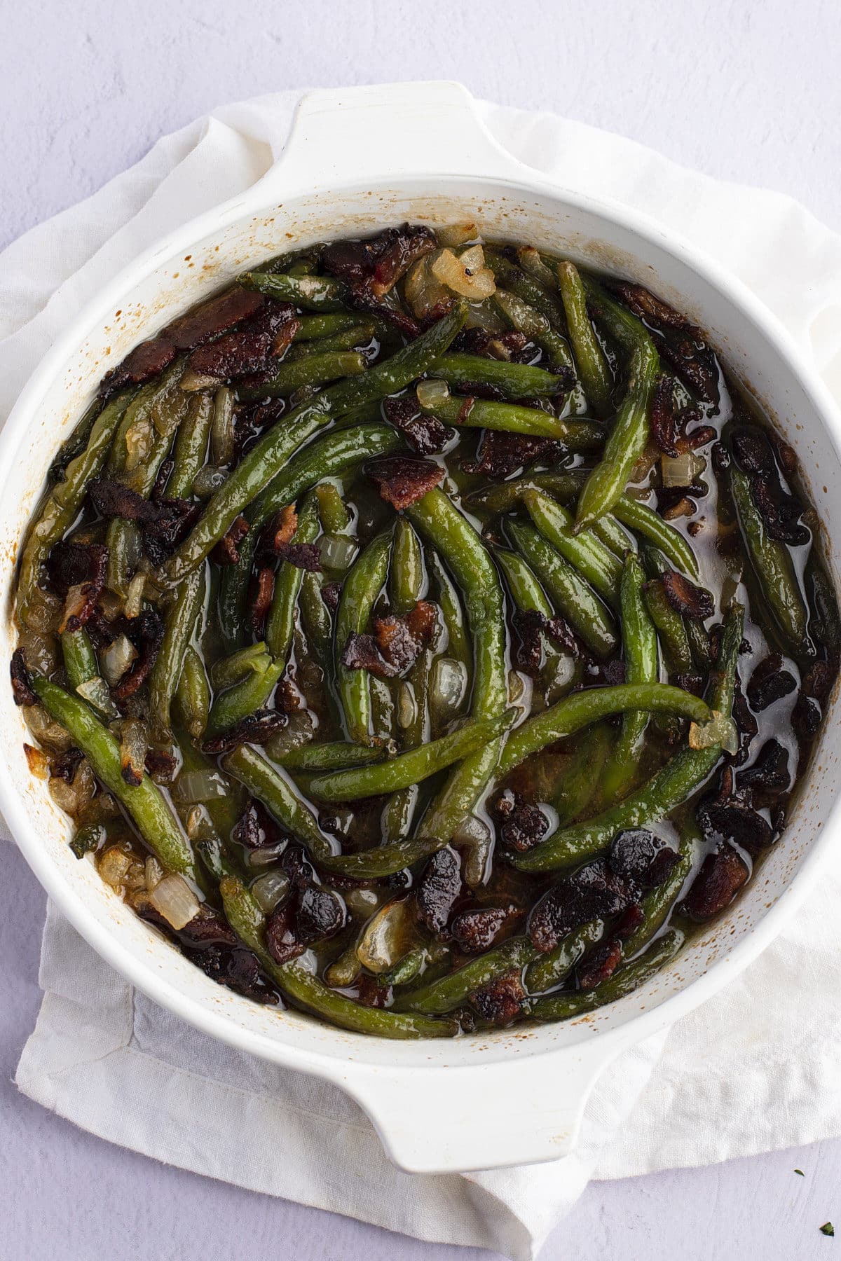 Baked smothered green beans in a white baking dish.