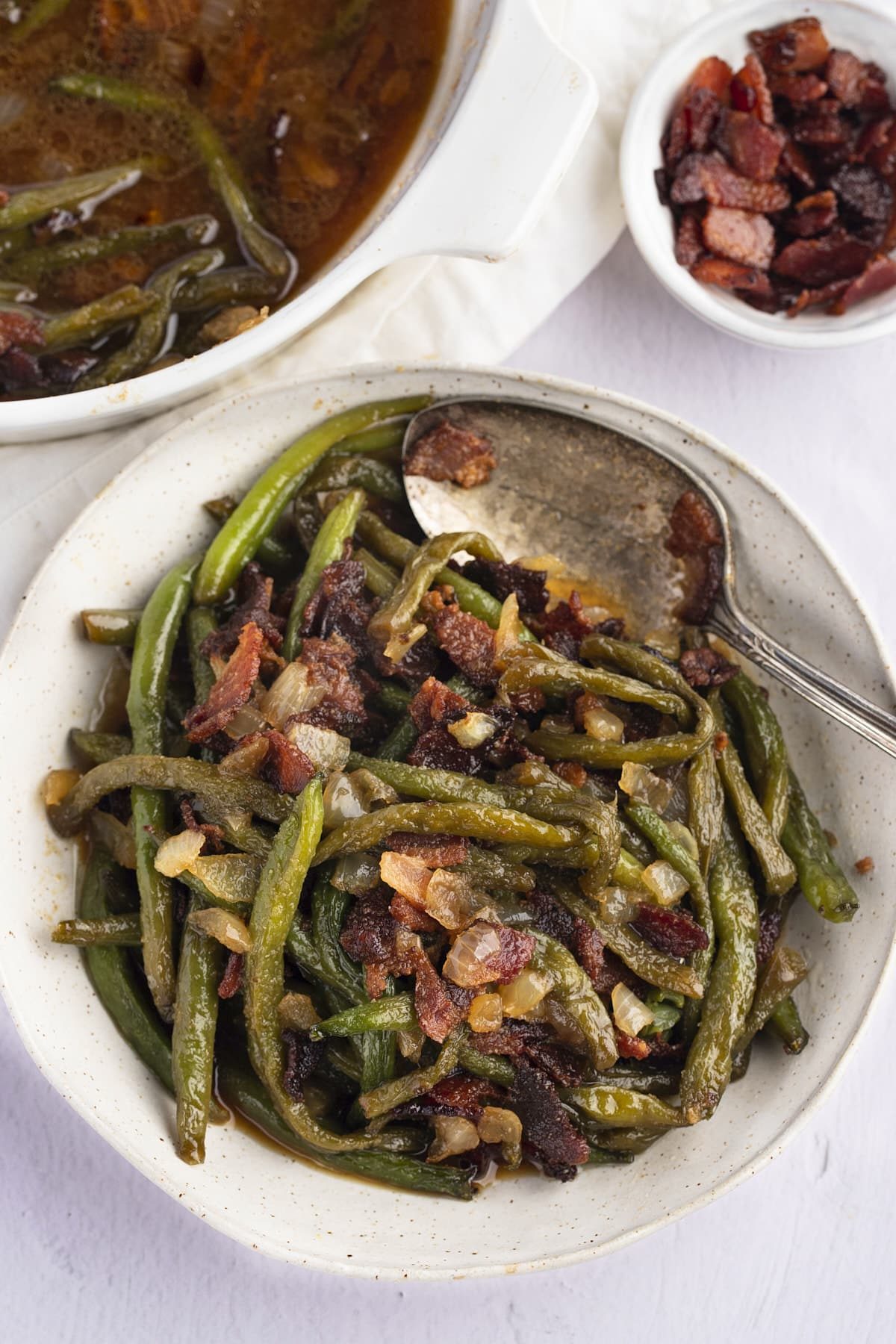 Overhead shot of green beans in a bowl with a spoon.