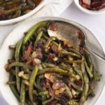 Overhead shot of green beans in a bowl with a spoon.