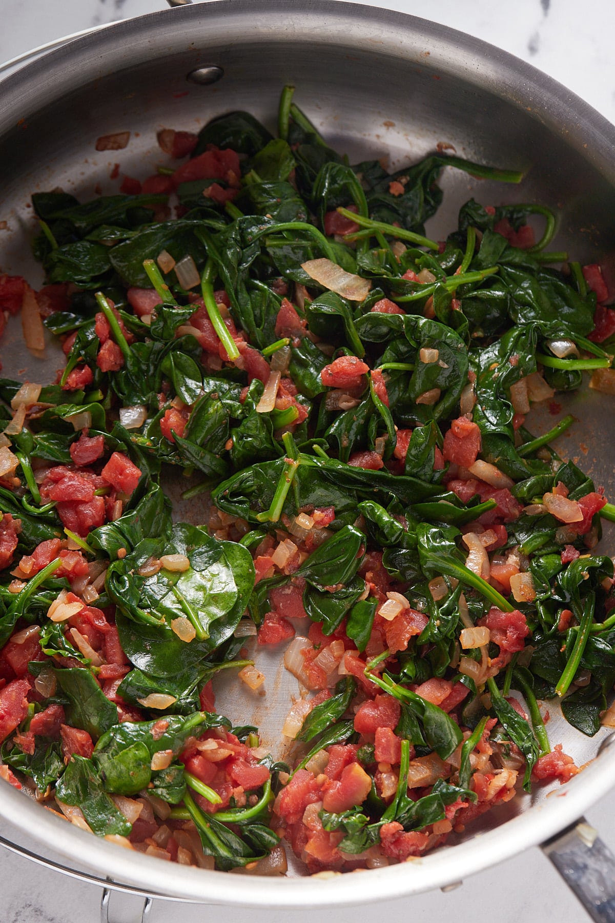 The wilted spinach in a skillet.
