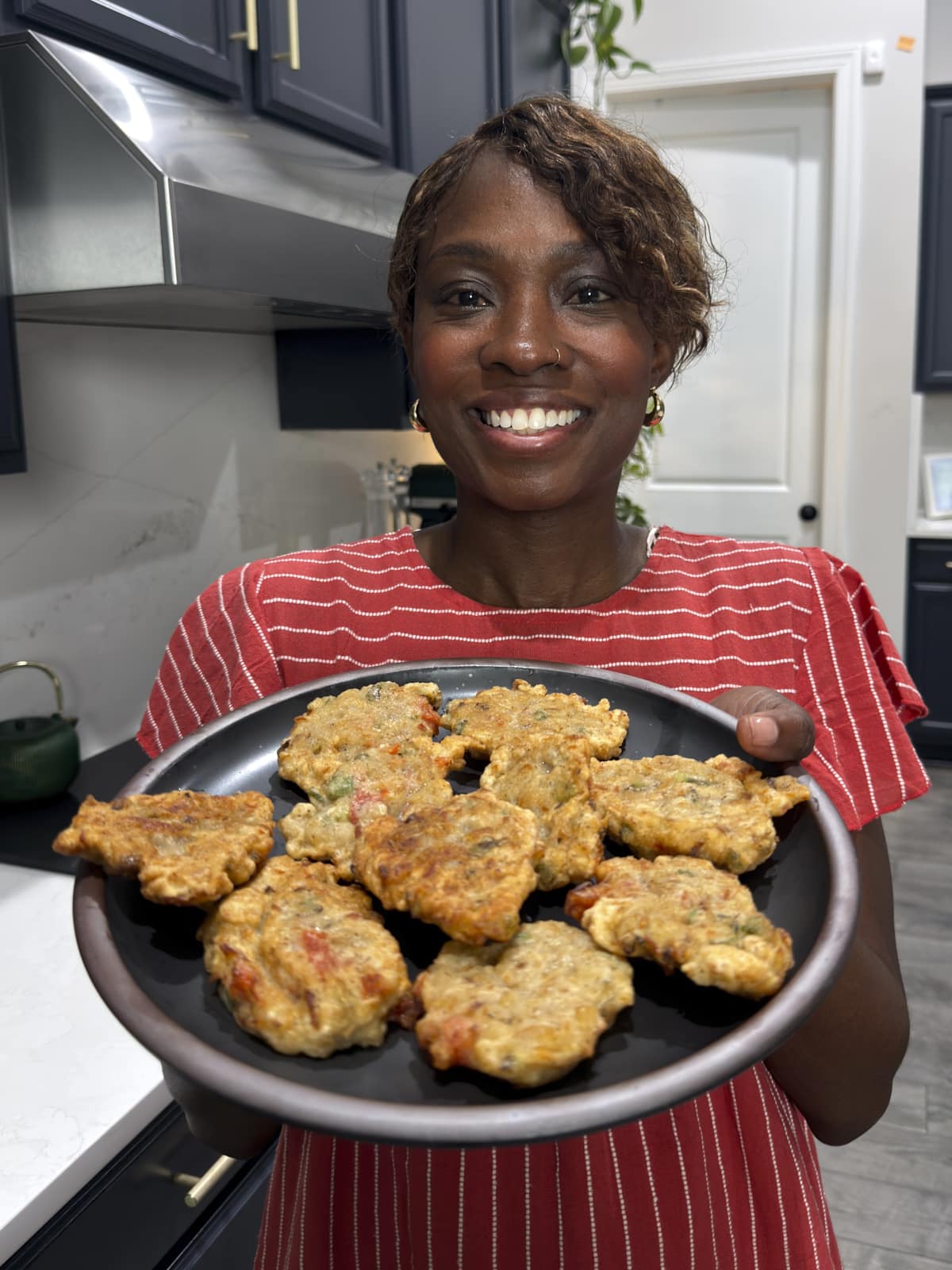 Tanya holding a plate of saltfish fritters