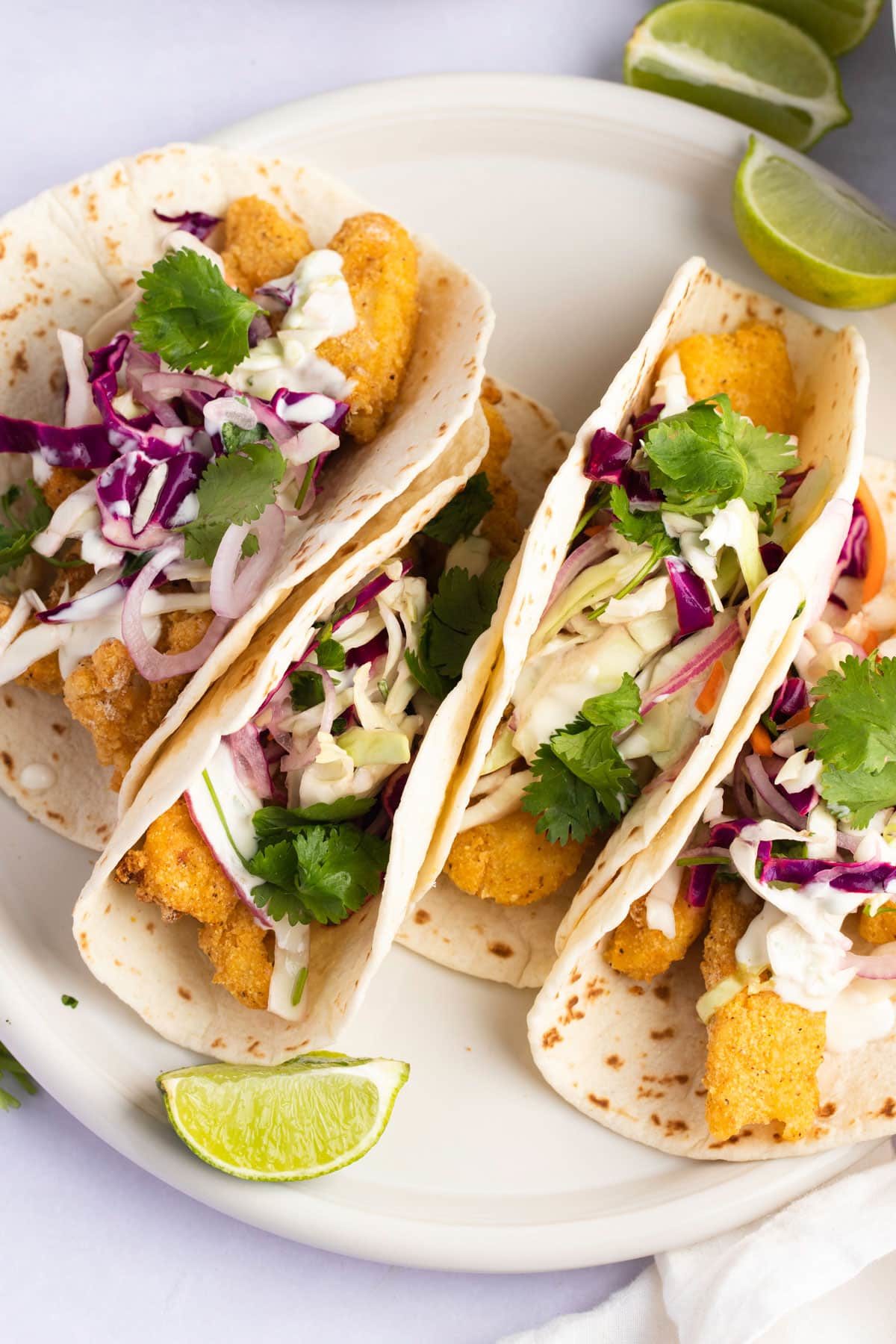 Crispy soft shell fish tacos topped with slaw and cilantro.