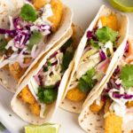 Crispy soft shell fish tacos topped with slaw and cilantro.