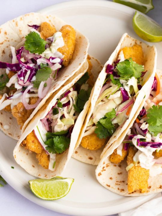 Crispy soft shell fish tacos topped with slaw and cilantro.