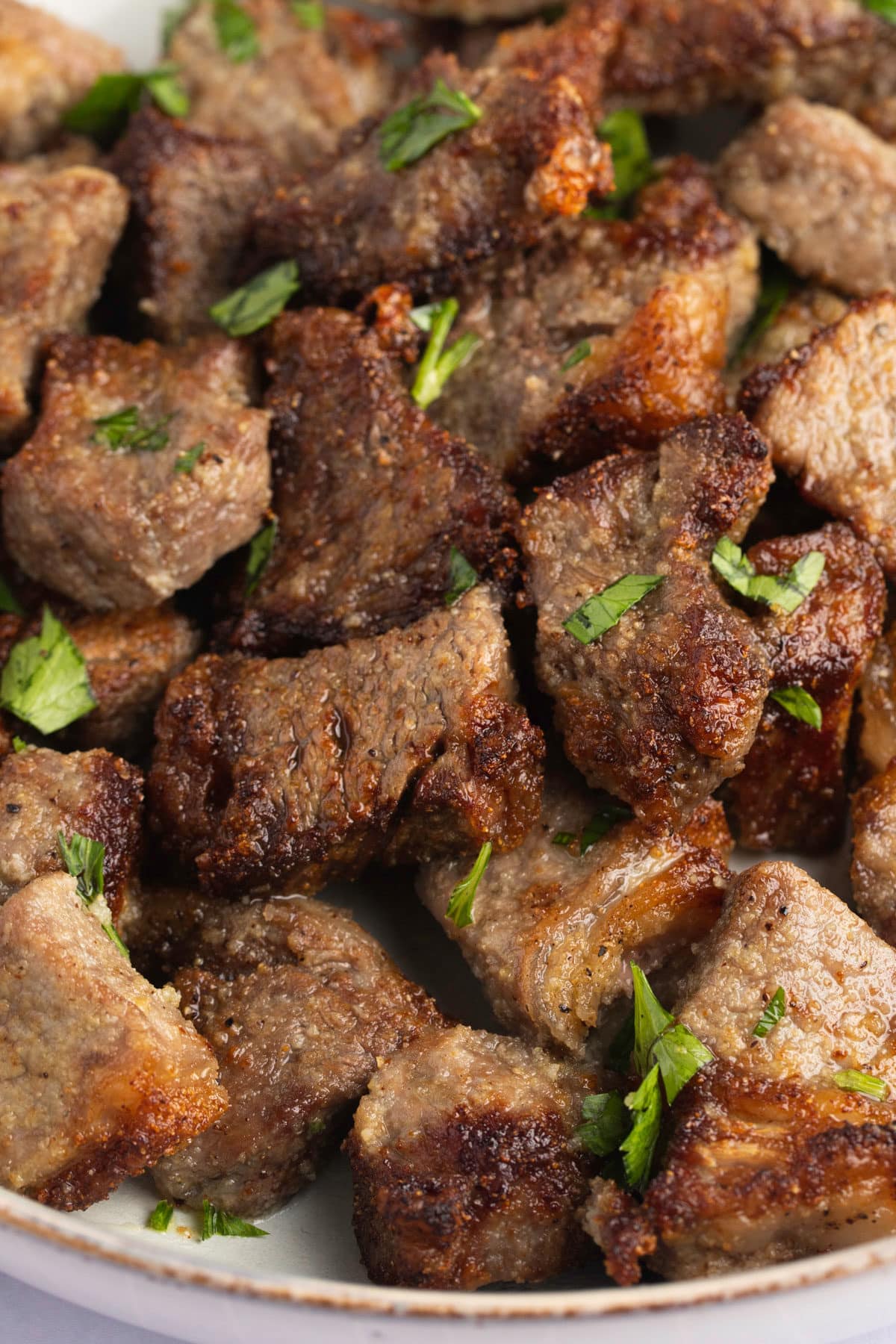 Air fried steak bites served on a white plate.