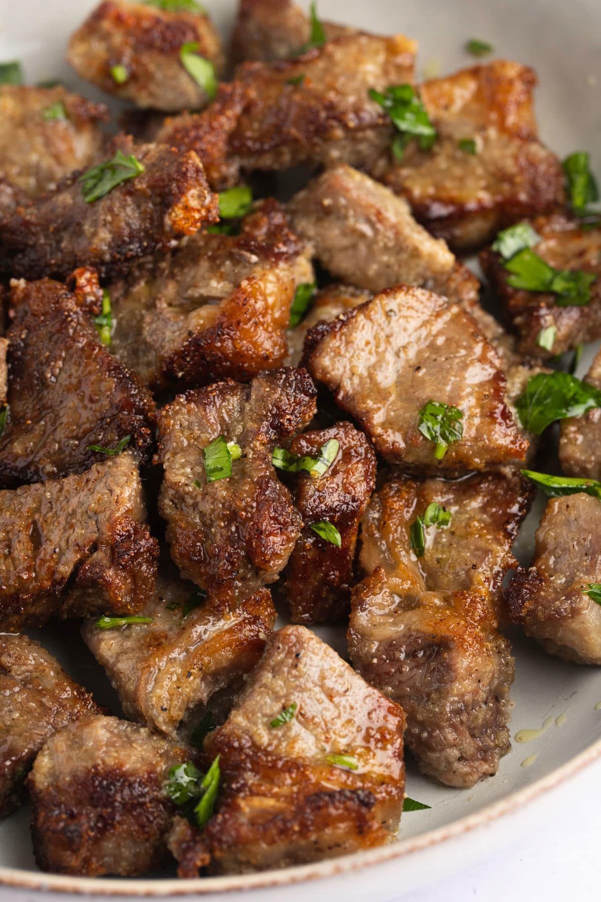 Air fryer steak bites garnished with fresh parsley.