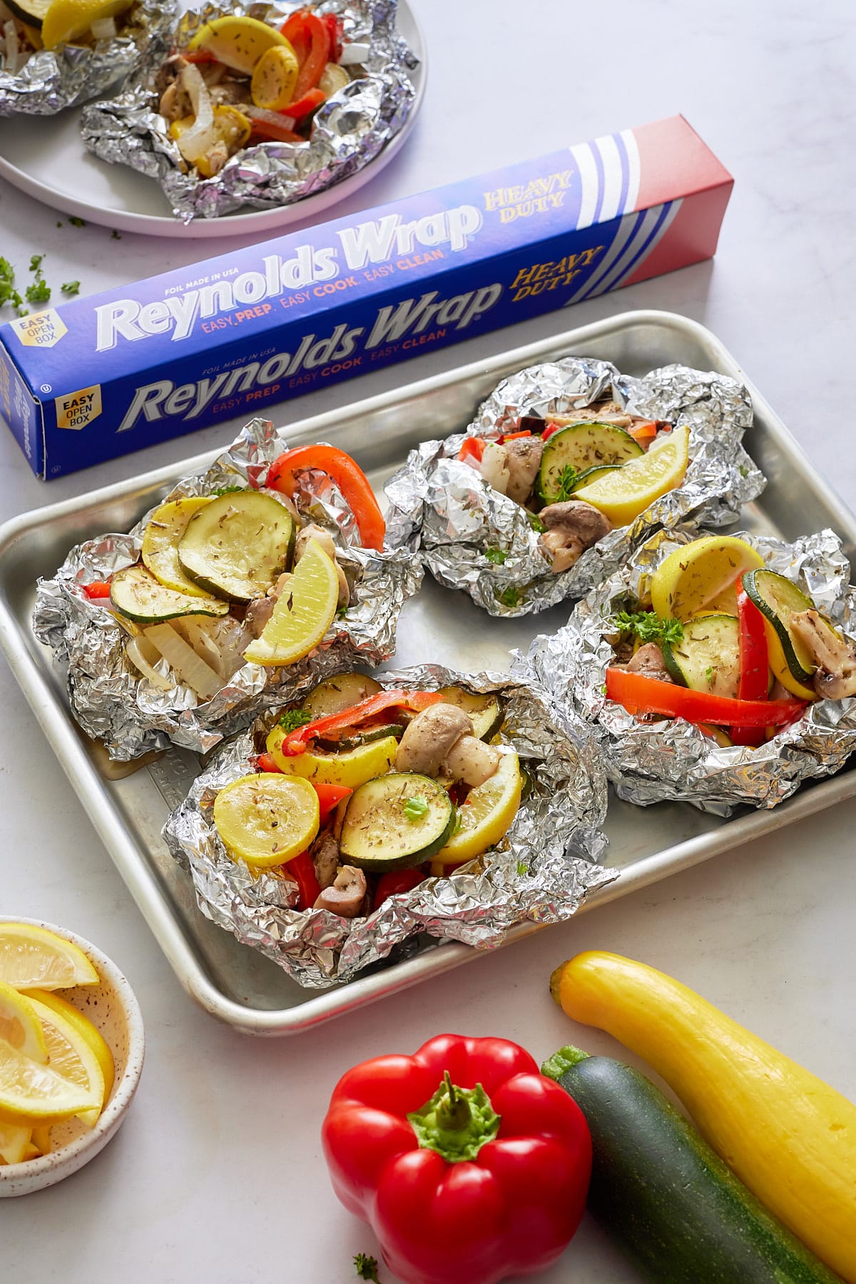 vegetables wrapped in foil on sheet pan