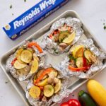 vegetables in foil packets on sheet pan with reynolds wrap box on side