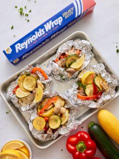 vegetables in foil packets on sheet pan with reynolds wrap box on side