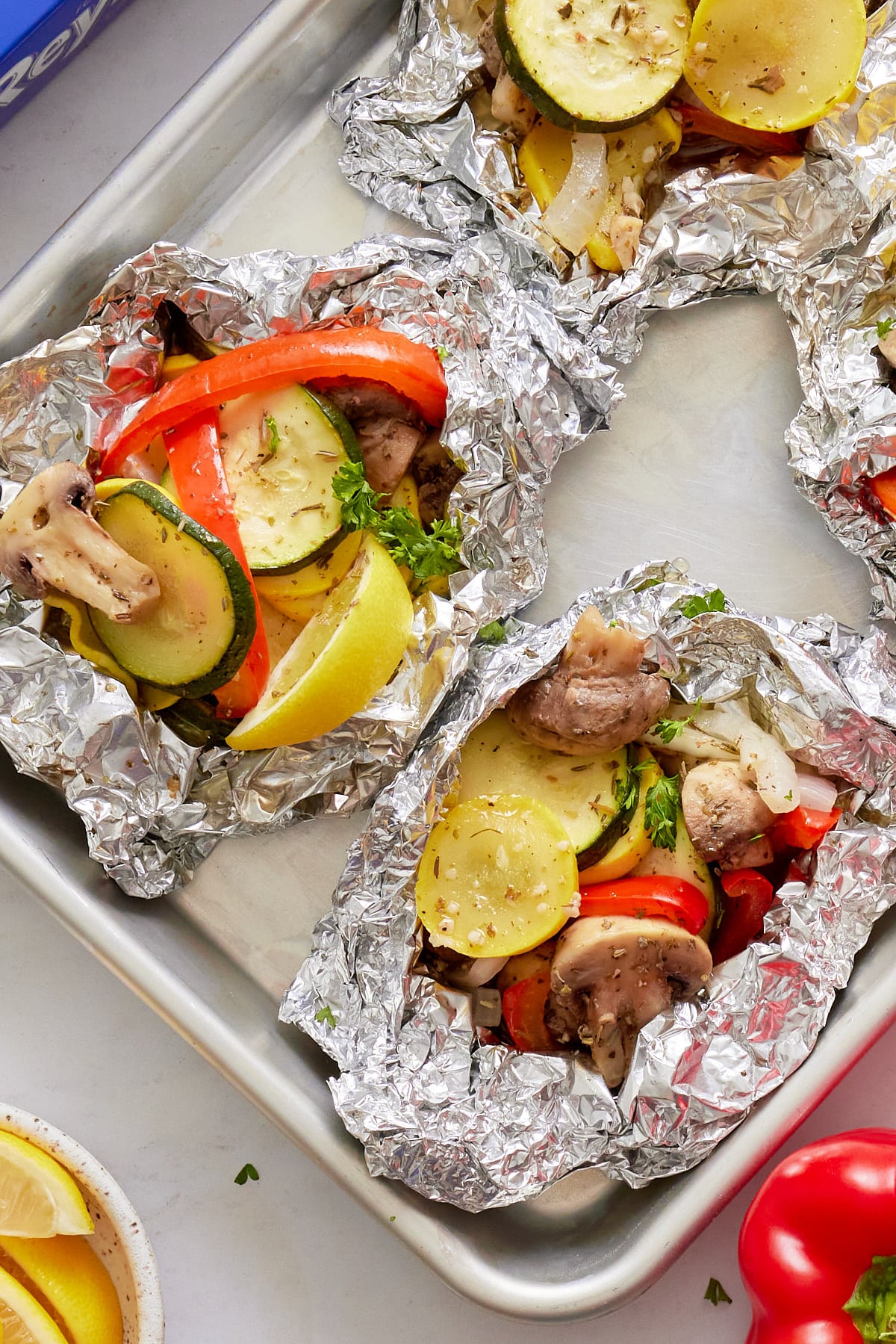 close up photo of grilled vegetables in foil packets