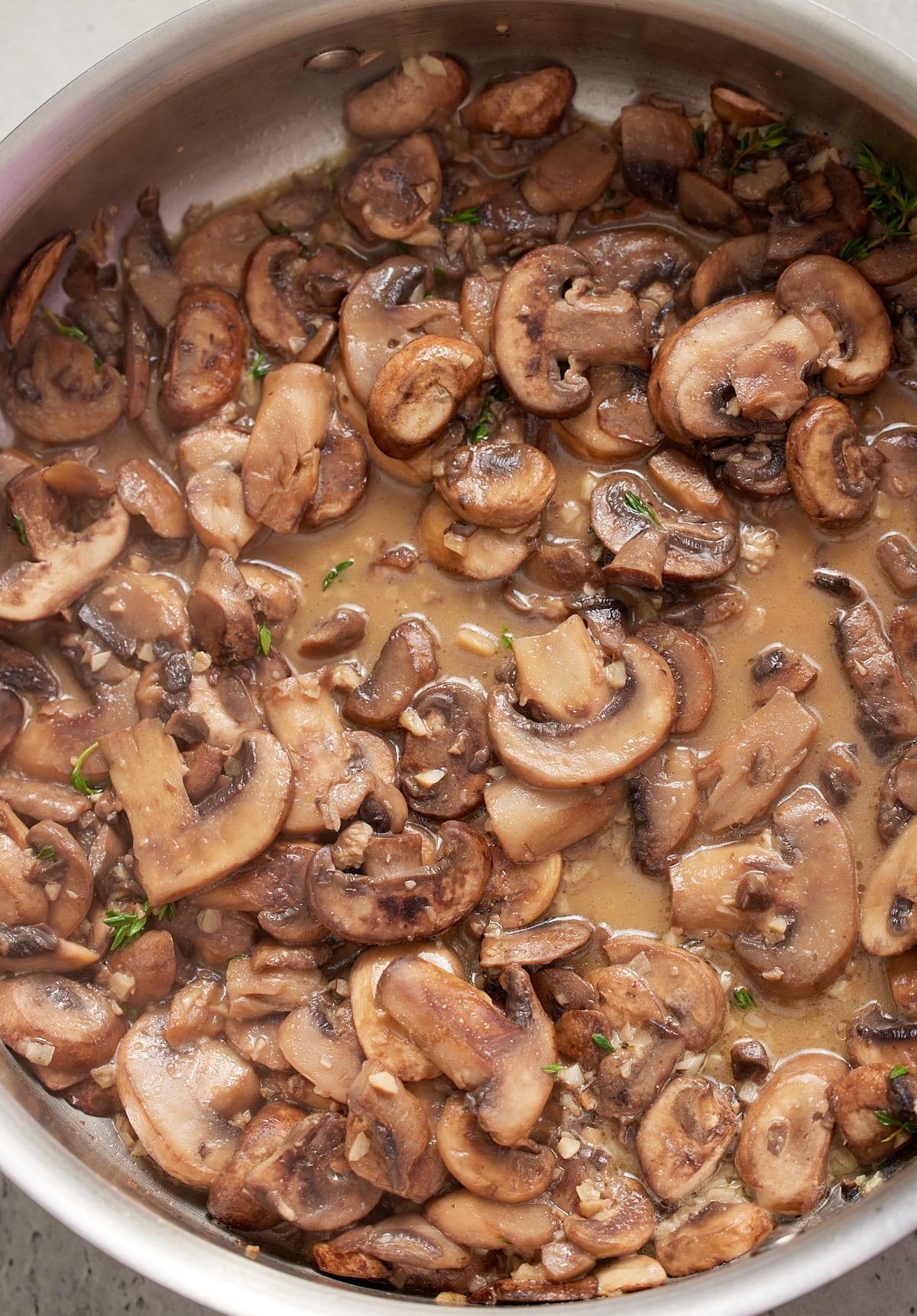 White wine and broth added to the mushrooms.