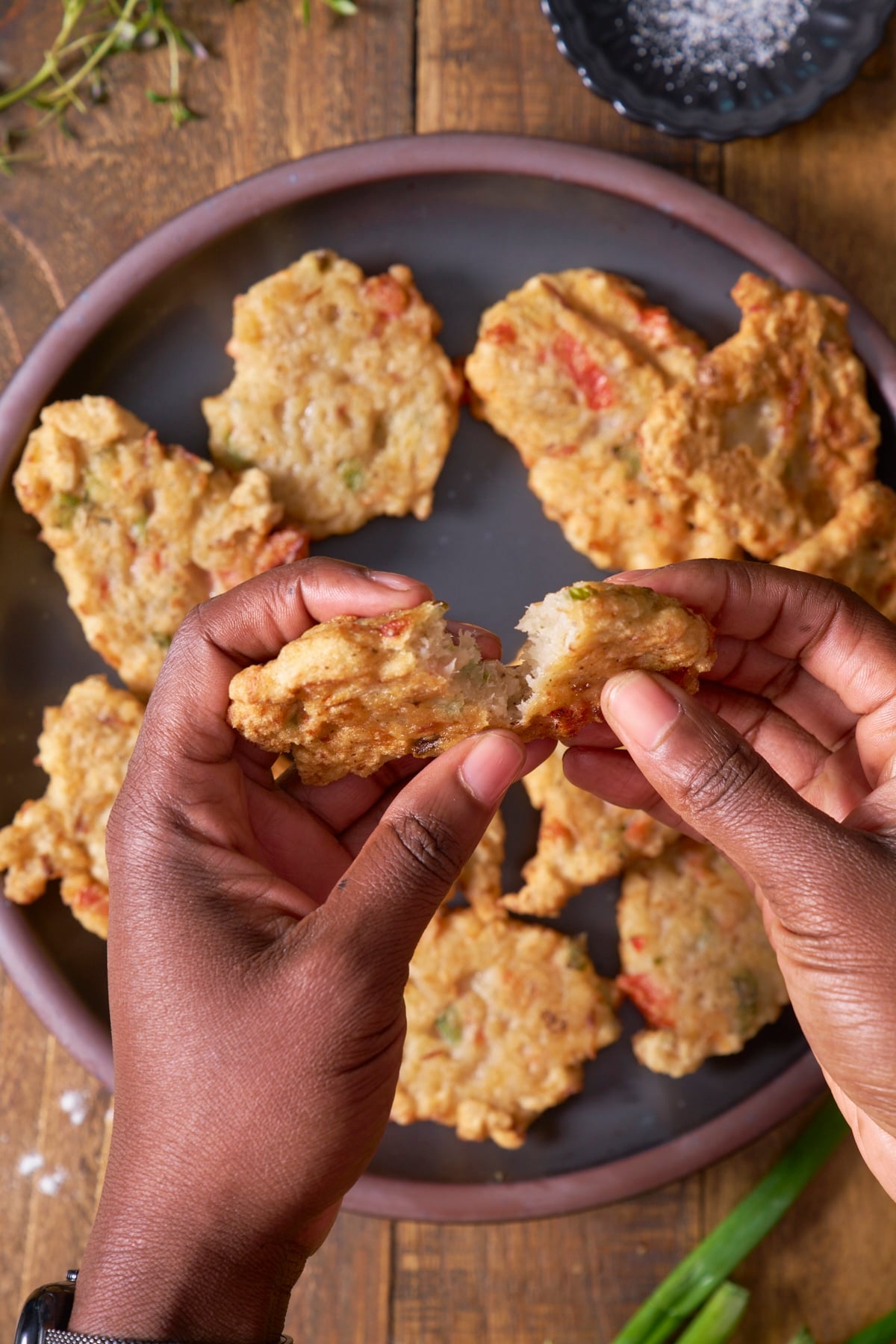 hand breaking saltfish fritters apart