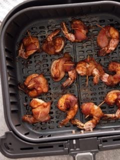 finished air fryer bacon wrapped shimp in air fryer basket