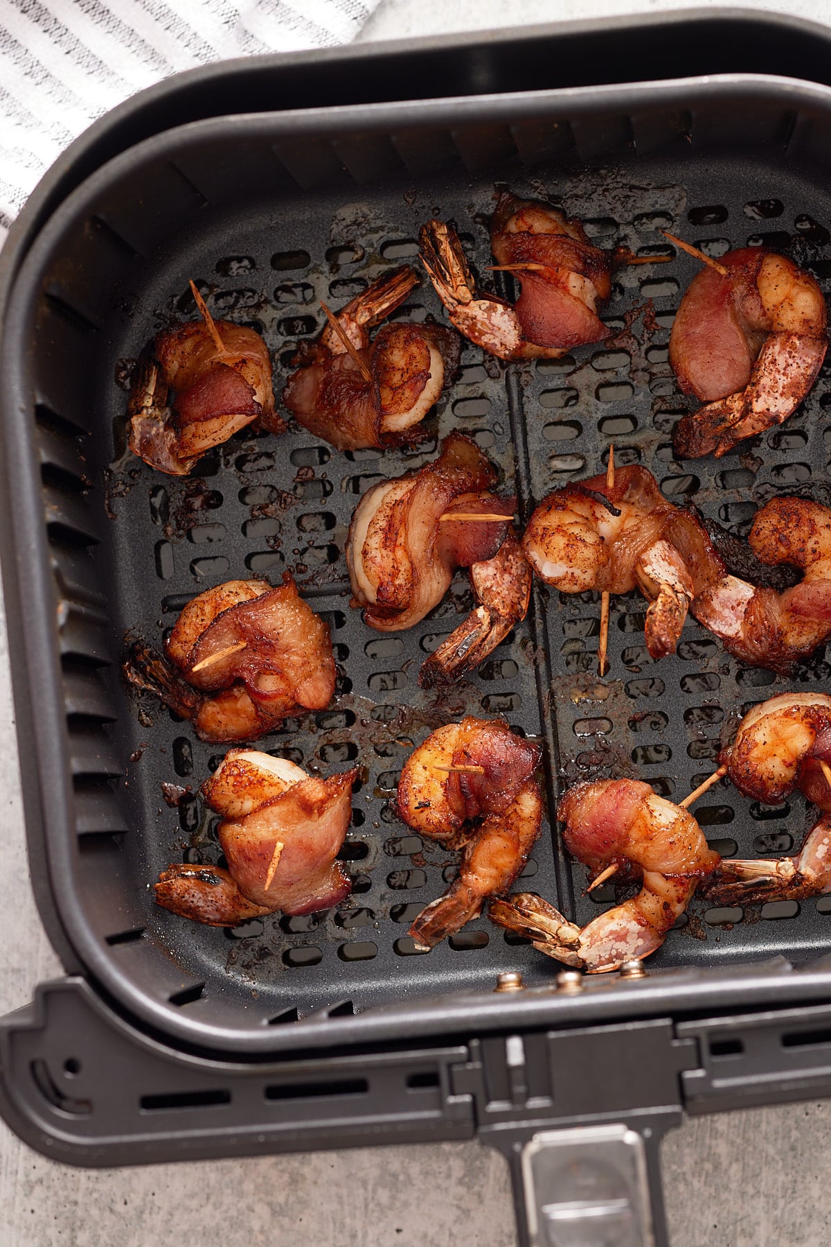 finished air fryer bacon wrapped shimp in air fryer basket