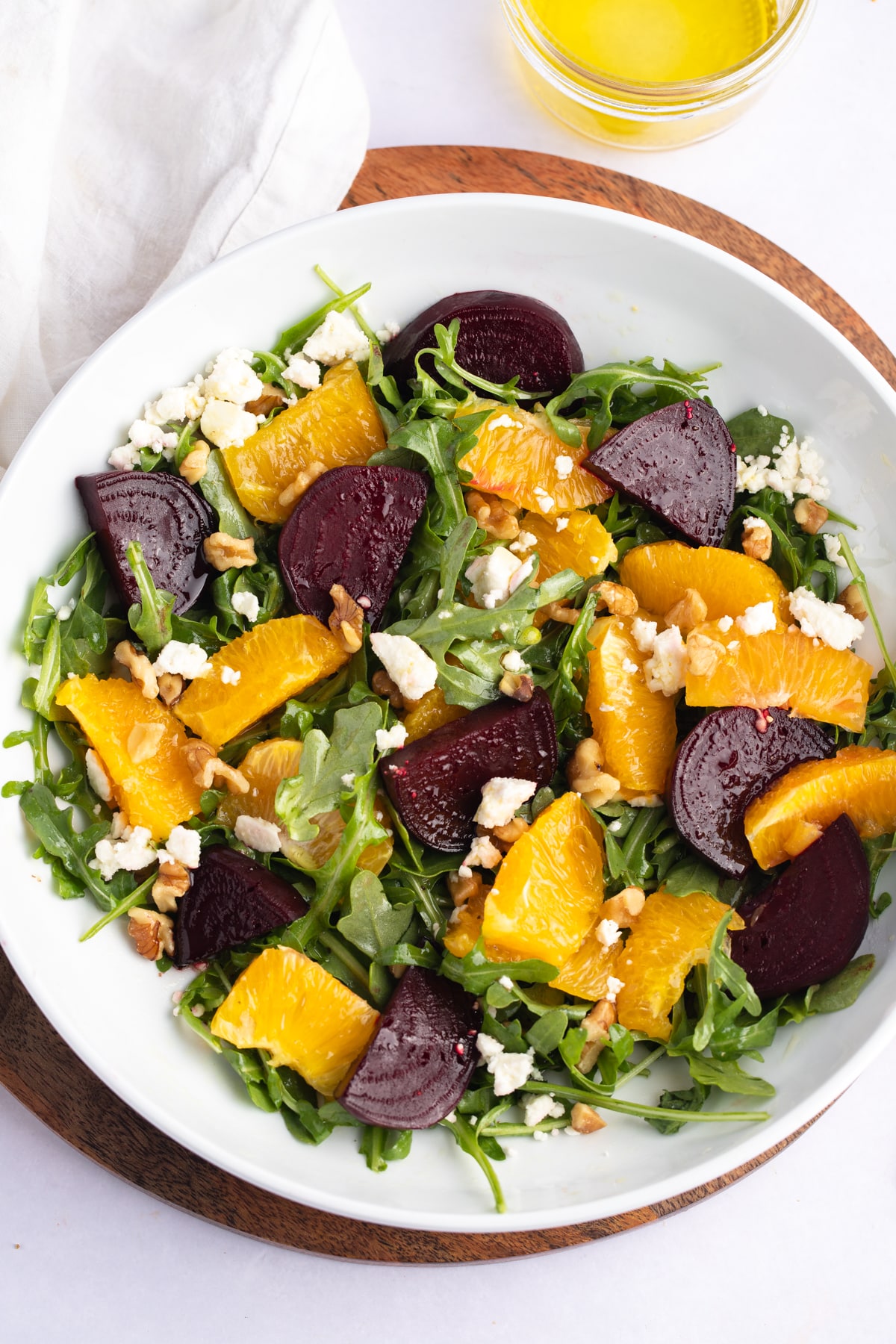 Overhead shot of roasted beet and orange salad in a white bowl.