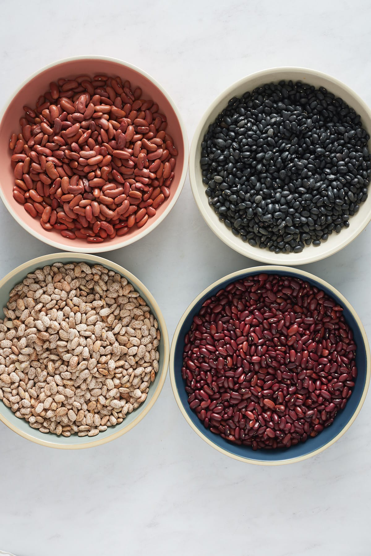 plates of dried beans on white background